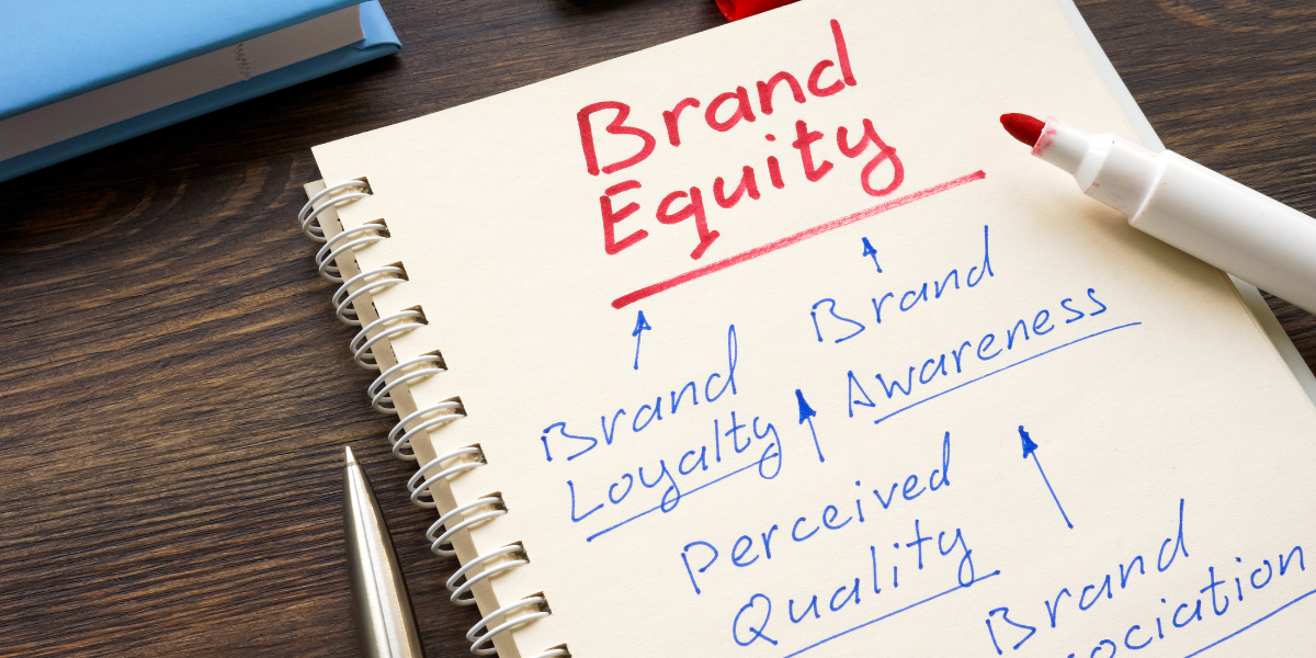 Notebook that says "brand equity" with the words "brand loyalty," brand awareness," "perceived quality," and brand association" written under it with arrows all pointing back to it.