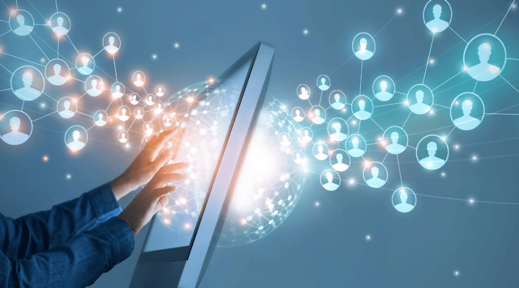 AI in digital marketing being used for market segmentation depicted by hands at computer monitor with account icons flowing through both sides of monitor and connected by data nodes.