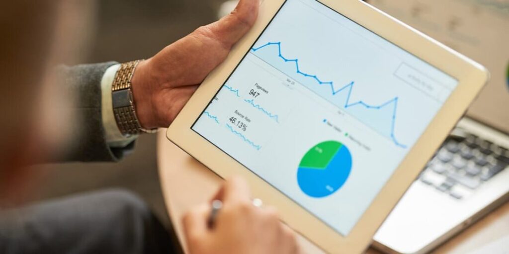 A man holds a tablet depicting website visitors, illustrating how inbound marketing helps a website collect visitors and leads.