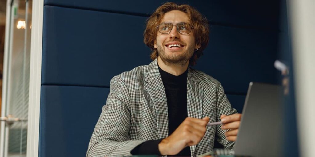 A young professional sits at his computer, learning about solutions for his work through inbound marketing.