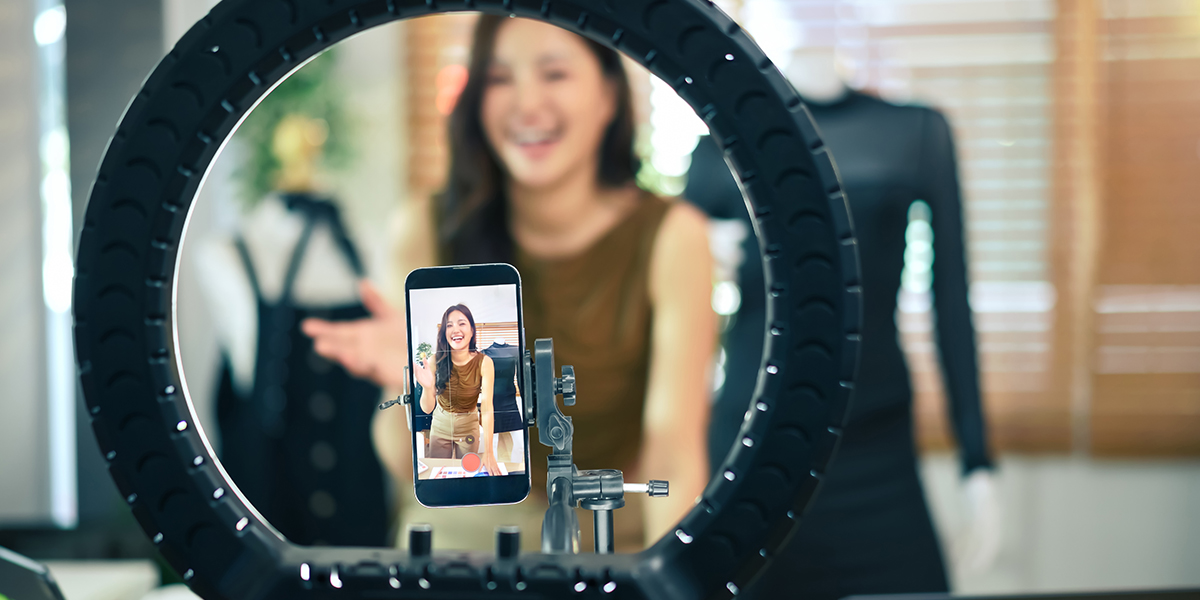 Closeup mobile phone recording video for tiktok, woman and mannequin in background